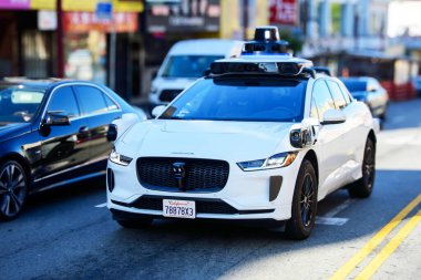 Waymo One Jaguar driverless car on urban street. Front side view. Selective focus - San Francisco, California, USA - June 22, 2024 clipart