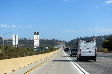Güneşli bir günde otoban trafiği ve yüksek yoğunluklu araç şeridi. HOV işareti araç başına iki veya daha fazla yolcu gereksinimini gösterir.