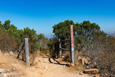 Big Rock Trail yürüyüş yolu ahşap bir direk ve işaretlerle işaretlenmiş, kurak bitki örtüsüyle çevrili - San Diego, California, ABD - 22 Ağustos 2024