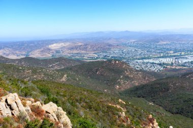 Overlook from Cowles Mountain with rugged hills and the city of Santee in the distance. clipart