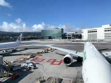 EVA Air uçağı San Francisco Uluslararası Havaalanı pistinde. Uzakta Grand Hyatt Oteli - San Francisco, ABD 3 Kasım 2024