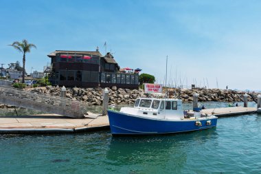 A blue fishing boat docked at Santa Cruz Harbor, with 