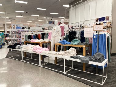 Katlanmış giysiler, günlük giysiler giymiş mankenler ve aydınlık bir mağazanın içinde giysi rafları sergileniyor. - Kaliforniya, ABD - 26 Temmuz 2024