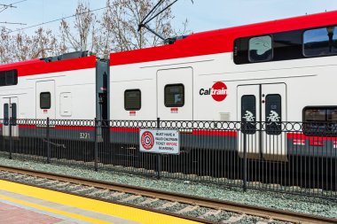 Caltrain çift katlı tren, güvenlik çitinin arkasında, üzerinde 