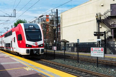 Çift katlı Caltrain elektrikli treni bir istasyona yaklaşıyor. Üzerinde 