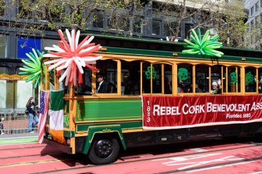 İrlanda ve Amerikan bayraklarıyla süslenmiş yeşil bir tramvay Aziz Patrick Günü Geçidi 2025 - San Francisco, California, ABD - 15 Mart 2025