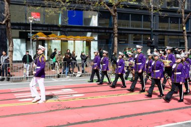 Mor üniformalı bando üyeleri, Market Caddesi - San Francisco, Kaliforniya, ABD - 15 Mart 2025 tarihli St. Patricks Günü Geçit Töreni 'nde kırmızı tramvay rayları üzerinde yürürler.