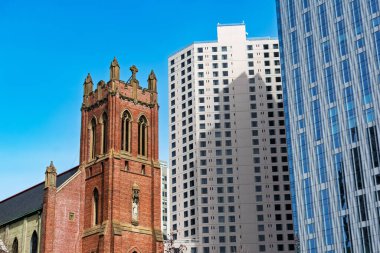 St. Patrick Katolik Kilisesi, kırmızı tuğlalı duvarlar ve sivri kemerlerle San Francisco 'nun güneyinde, modern gökdelenlerin yanında duruyor.