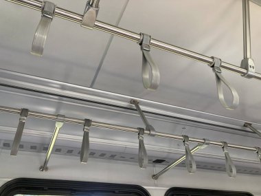 Bir banliyö treni veya otobüsü içinde boş tavana monte edilmiş tutacaklar ve destek çubukları.