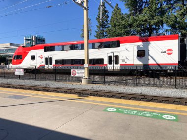 Bir Caltrain çift katlı treni, çit, tabelalar, Palo Alto, California, ABD - 7 Mayıs 2025 tarihlerinde, yeşil bisiklet biniş bölgesini gösteren bir platformun karşısında durduruldu.