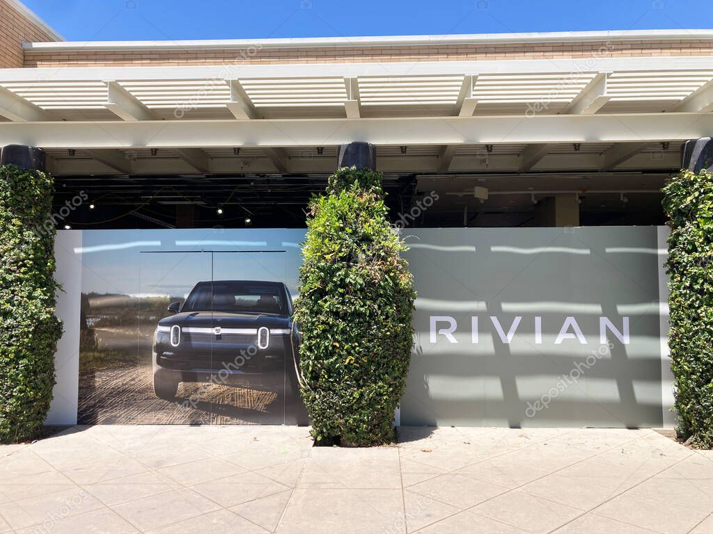 Rivian sign and Rivian EV truck promotional photo on showroom store facade exterior - Palo Alto, California, USA - May 27, 2025