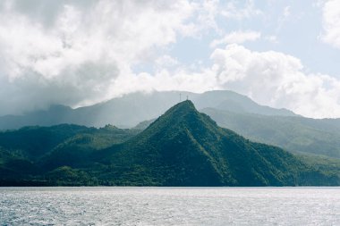 Karayipler 'deki ağaçlarla kaplı tepelerin ve dağların manzarası. Atlantik Okyanusu 'nun suları boyunca yağmur ormanları.
