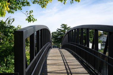 Footpath arched bridge with metal black railing in town