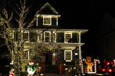 Christmas decorations glowing outside at night in front of a house. Christmas lights