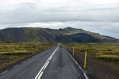 Bulutlu bir günde İzlanda 'nın doğal ortamında boş yol veya otoyol