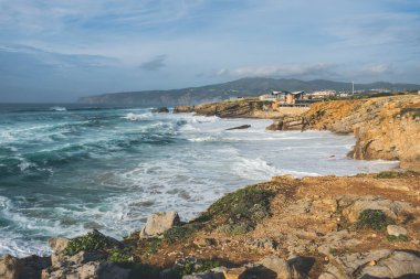 Cascais, Portekiz 'deki Atlantik Okyanusu kıyısında. Dalgalar kıyıda ve kayalık tepelerde