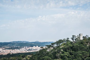 Portekiz 'deki Sintra' nın havadan görüntüsü. Uzaktan görülen eski bir şehir. Binalar ve ormanlarla dolu bir manzara.