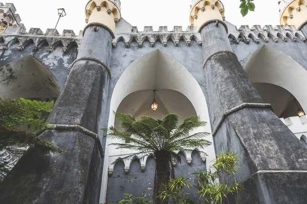 Palmiye ağaçları olan bir sarayda veya kalede kolları ve kavisli bir duvar.