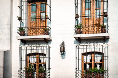 Dört simetrik balkon ahşap pencere kapısı güvenlik için demir parmaklıklarla korunuyor.