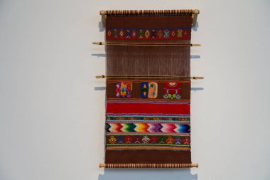 Çizgili El Dokuması Eski Kilim ya da beyaz duvara asılı ahşap bir askıda asılı halı