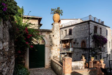 Merdivenlerde saksı bitkisi olan bir binanın ön cephesi. Sicilya, Taormina 'da bir binanın girişi.