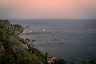 Taormina, Sicilya 'daki tepeden denize ve tren istasyonlu uçurumlara bakın.