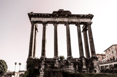 Ruins of Temple of Saturn located against cloudless sky in roman forum in Rome, Italy clipart