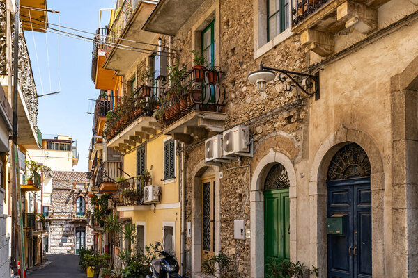 View of old stone buildings with potted plants on balconies on a summer day in Rome, Italy