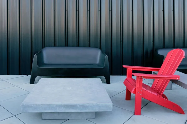 Outdoor furniture consisting of red chairs and concrete table placed outside on a terrace