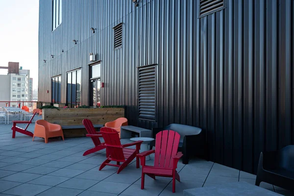 Outdoor furniture consisting of red chairs and concrete table placed outside on a terrace