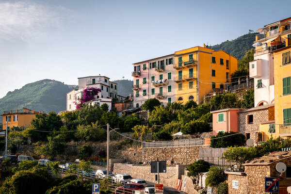 Corniglia, Italy - July 11 2023: View of colorful apartment buildings on a hill on a sunny day in Corniglia, Cinque Terre, Italy