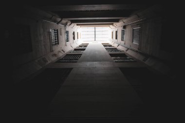 Binanın bacasından yukarıya doğru bakıyor. Pencereli karanlık koridor
