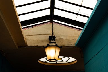 Lamba, tavandan sarkan kolye. Ahşap çerçeve ve camdan yapılmış tavan penceresi.