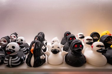 Bir mağazanın rafında hediye olarak satılan çeşitli sarı plastik oyuncak ördekler.