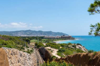 Sitges 'in uzaktan görüntüsü. Tren rayları. Kıyı, deniz ve dağların manzarası