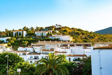 İspanya, Kadavra 'da Akdeniz mimari tarzı. Gün batımında palmiye ağaçları olan beyaz apartmanlar.