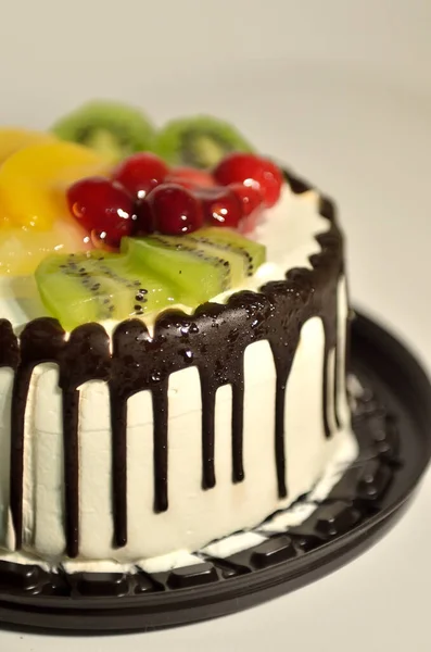 奶油蛋糕 水果与糖浆一起倒入白色背景中 — 图库照片