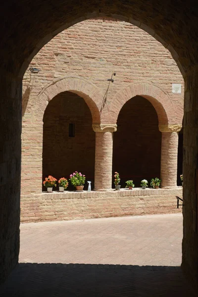 Cloister with ancient brick arches and flowers in the heart of Tuscany.