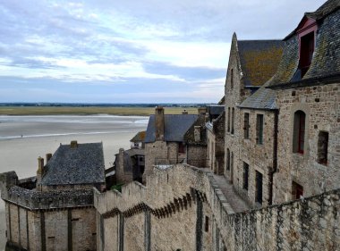 Mont Saint-Michel, Normandiya ve Brittany arasında yer alır ve düşük gelgitleriyle bilinir. St. Vincent Benedictine Manastırı 'nın eteklerindeki eski kasabada cazibe.