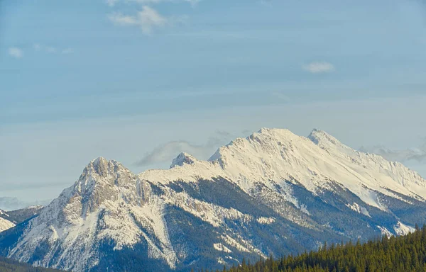 Landscape of Snow capped mountains with light blue sky in Kananaskis, Alberta
