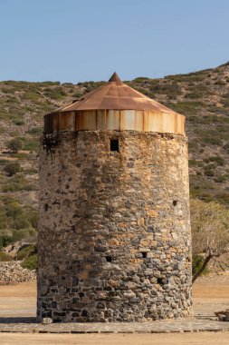Yunanistan 'ın Girit bölgesindeki Elounda bölgesinde sahil boyunca uzanan antik yel değirmenlerinin kalıntıları.