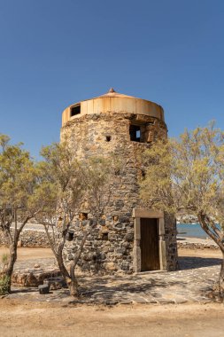 Yunanistan 'ın Girit bölgesindeki Elounda bölgesinde sahil boyunca uzanan antik yel değirmenlerinin kalıntıları.