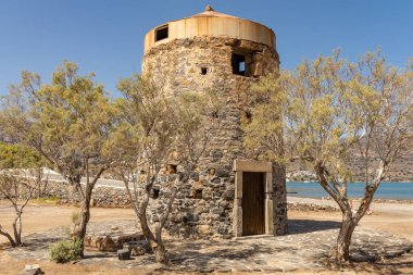 Yunanistan 'ın Girit bölgesindeki Elounda bölgesinde sahil boyunca uzanan antik yel değirmenlerinin kalıntıları.