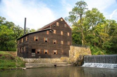 Pine Creek Grist Mill, built in 1848, on a sunny summer morning at Wildcat Den State Park.  Muscatine, Iowa, USA. clipart