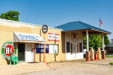 Williamsville, Illinois, ABD - 15 Mayıs 2025 - Eski Route 66 'da eski benzin pompaları ve diğer antika hatıraları olan eski bir benzin istasyonu.