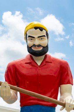 Tulsa, Oklahoma, ABD - 18 Haziran 2025 Meadow Gold Mack, baltasını kullanan dev bir Egzoz Adam heykeli. Tulsa, Oklahoma.