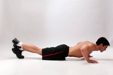 Seksi adam iç mekanda egzersiz yapıyor..