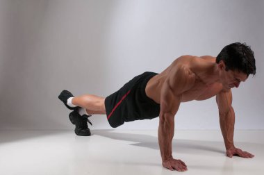 Seksi adam iç mekanda egzersiz yapıyor..