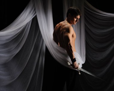 seksi adam bir kılıç tutuyor