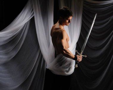 seksi adam bir kılıç tutuyor